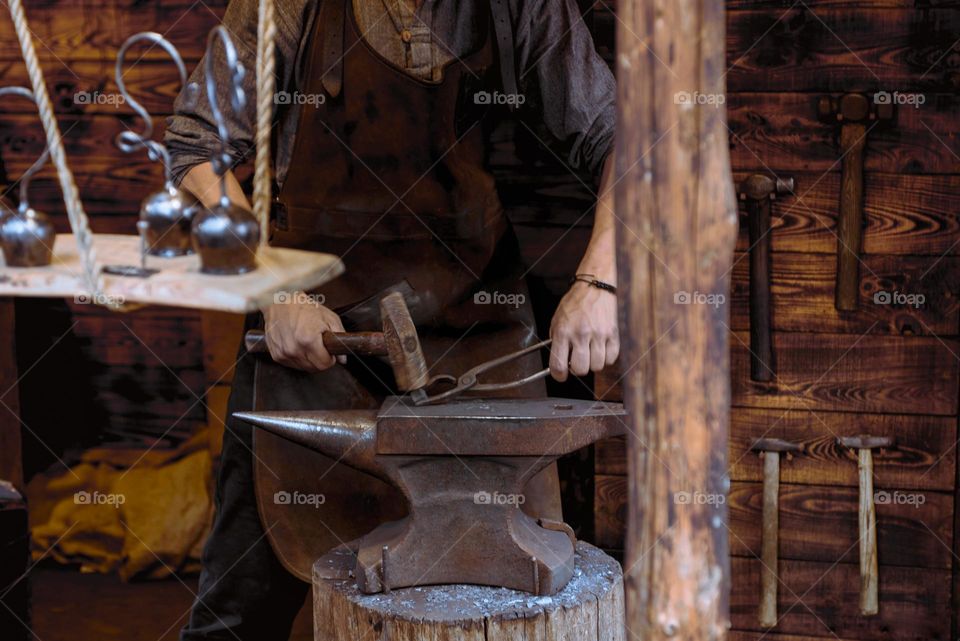 The blacksmith forges a horseshoe.  Iron forging machine close-up.