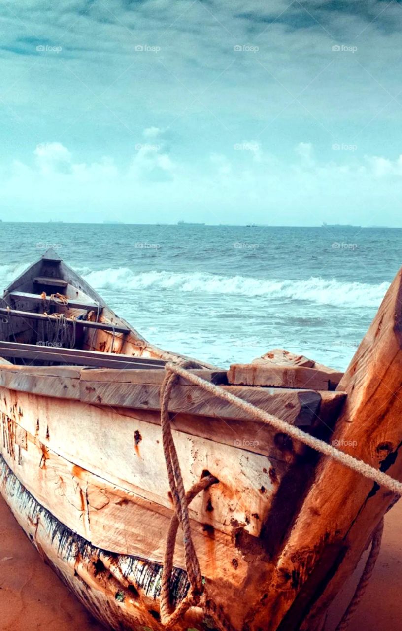 nice seashore photo also beautiful wooden small boad on sand nice blue water overall so nice image