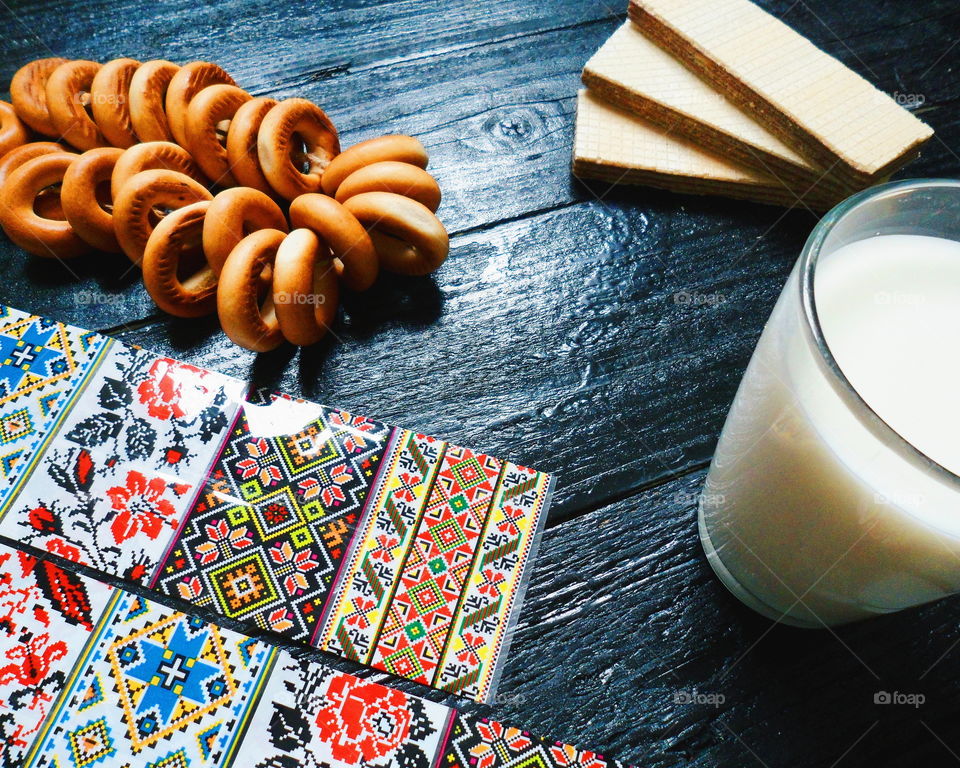 cakes, a cup of milk, bagels and waffles on a black background