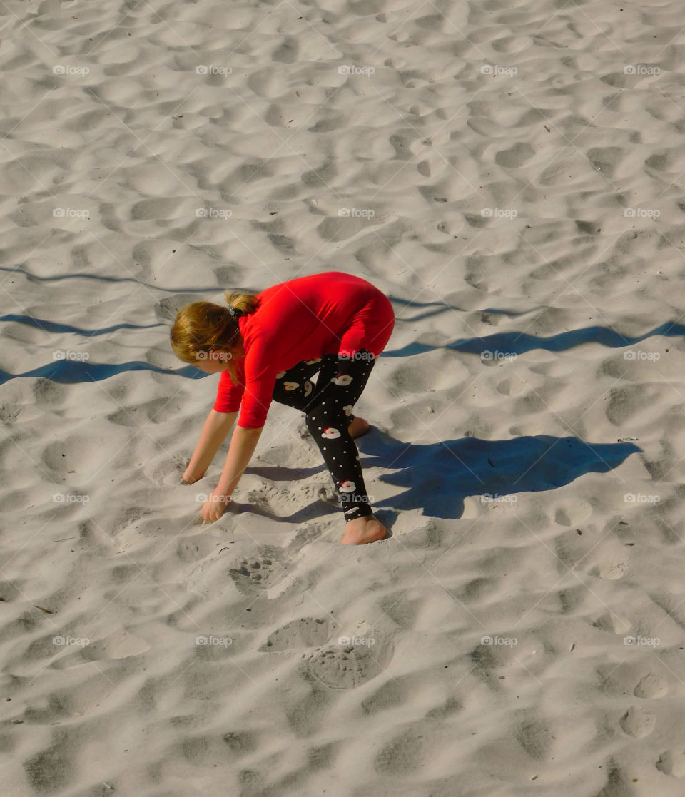 Young girl plays in Southern snow (white SAND) around the Gulf of Mexico!