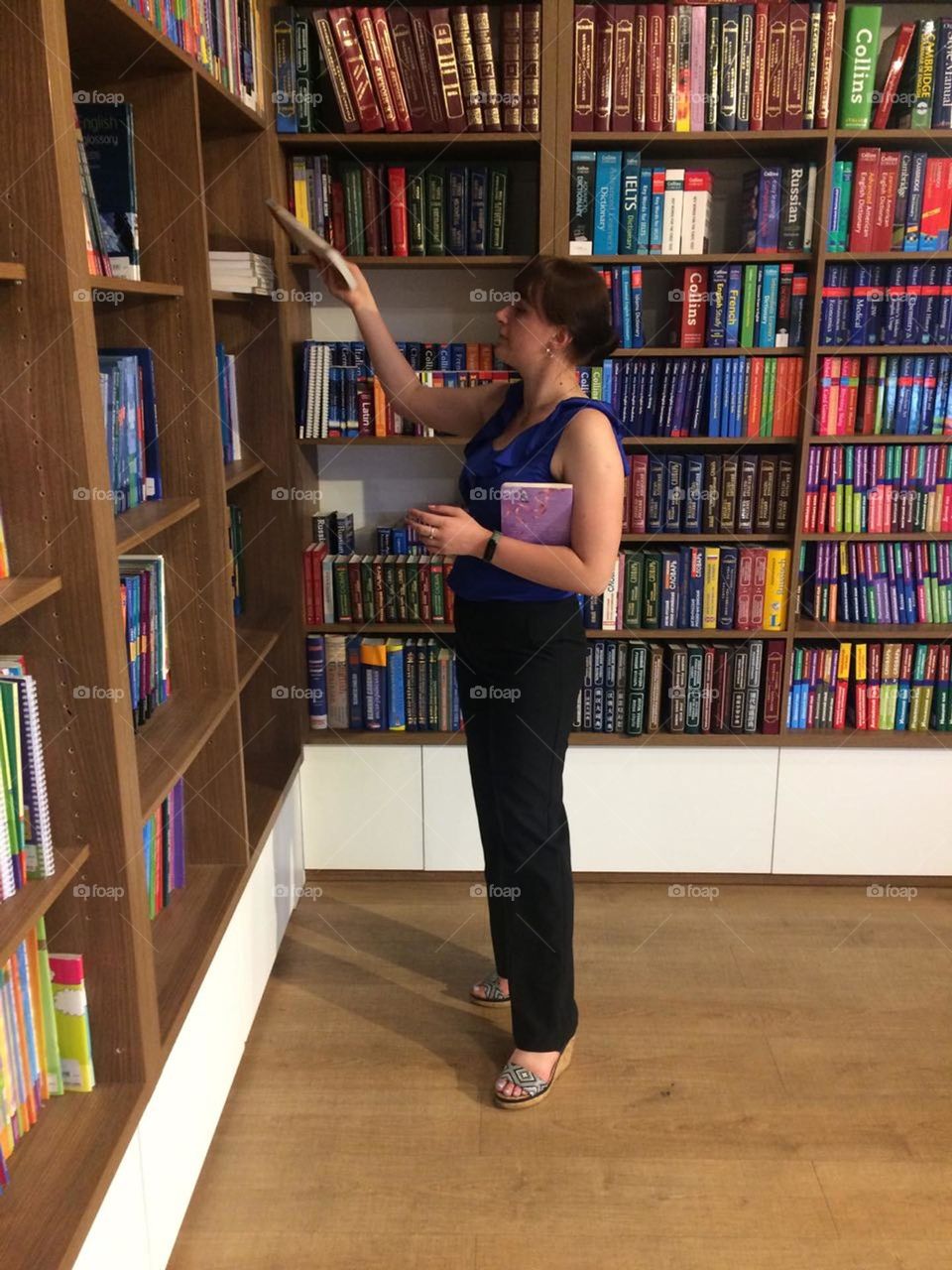 A girl in a bookstore chooses literature to read