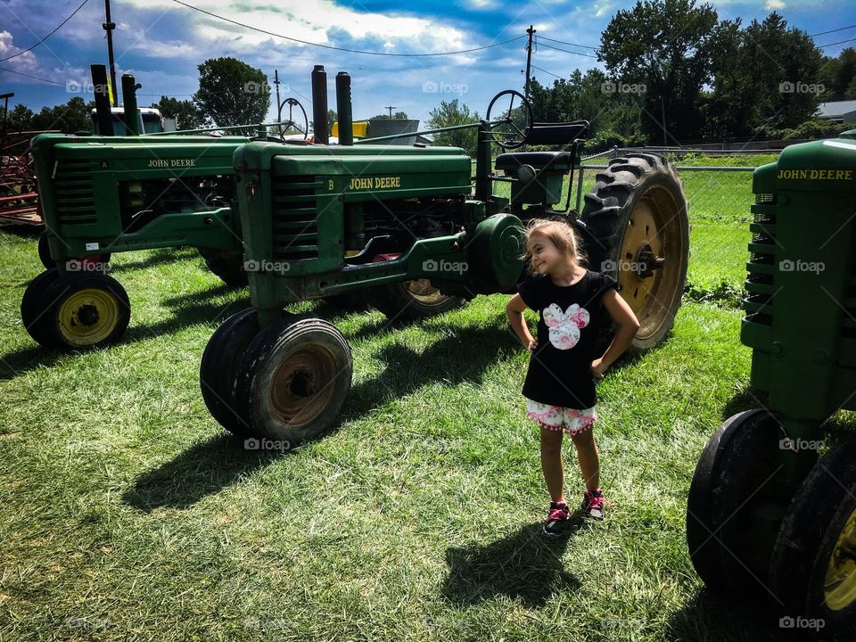 My daughter and some antique John Deere tractors