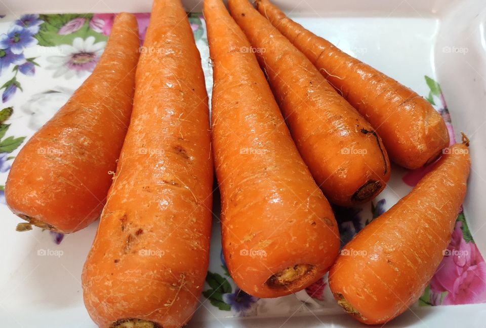 bunch of fresh carrots in a white ttay