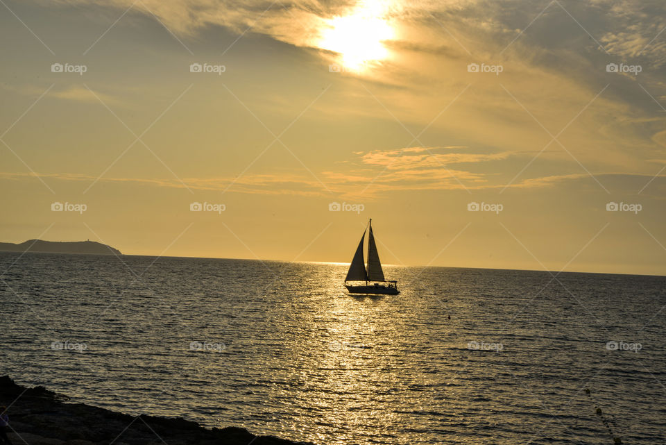 Yatch sailing at sunset in Ibiza, Spain