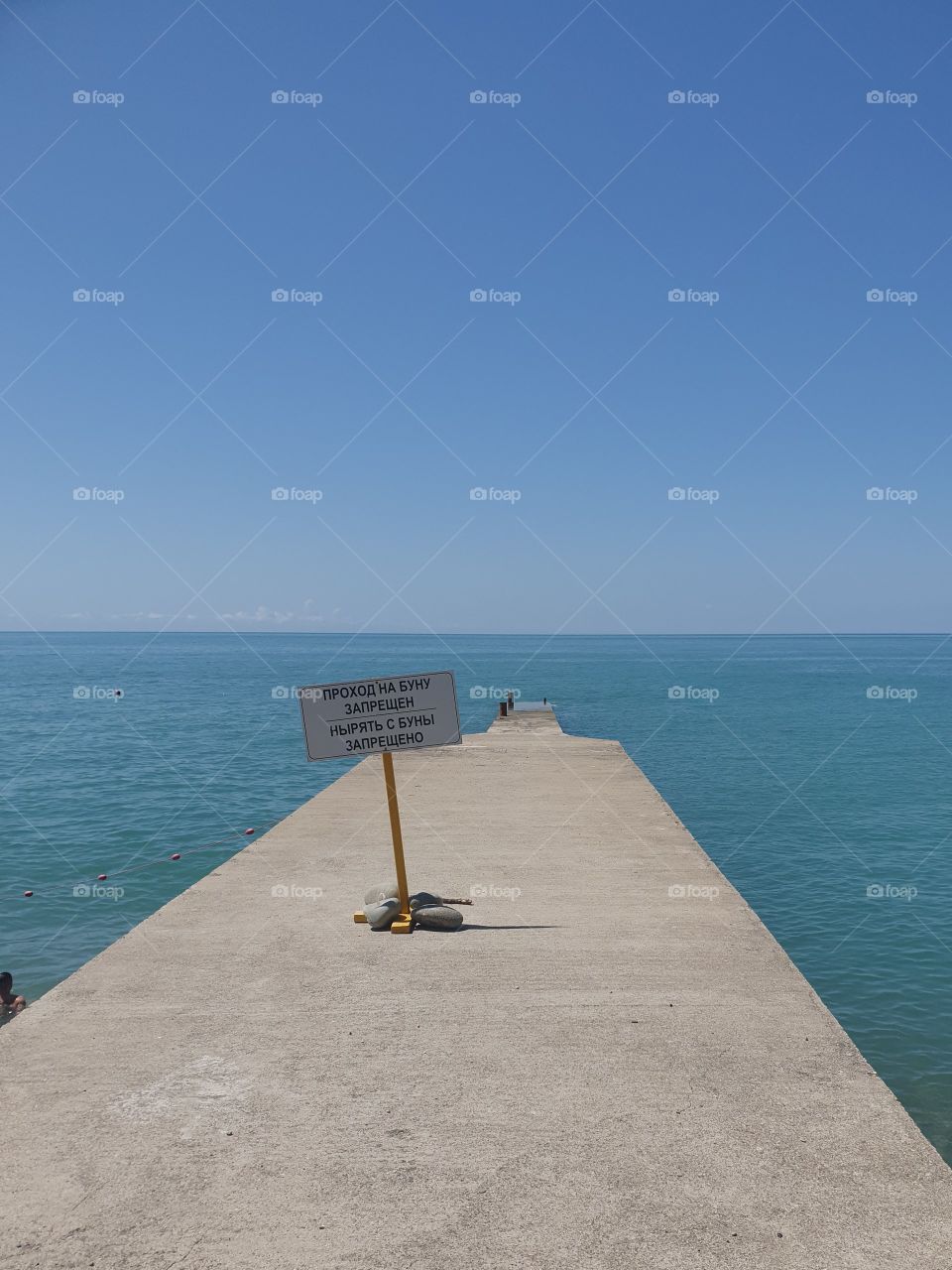 The sign "Hiking to the buna is prohibited. Diving from the buna is prohibited" at the entrance to the buna