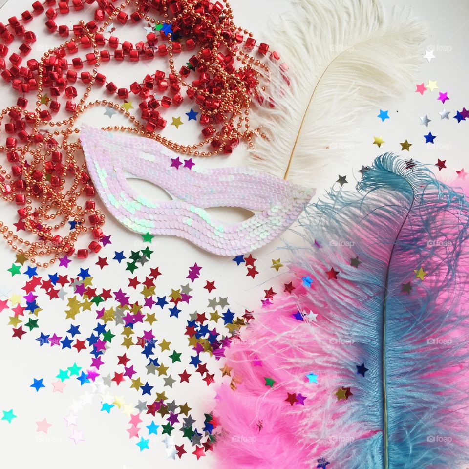 Eye mask, bead necklace and feather for carnival event