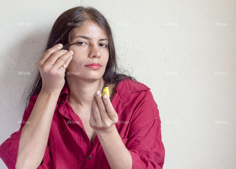 Woman applying eyeliner.