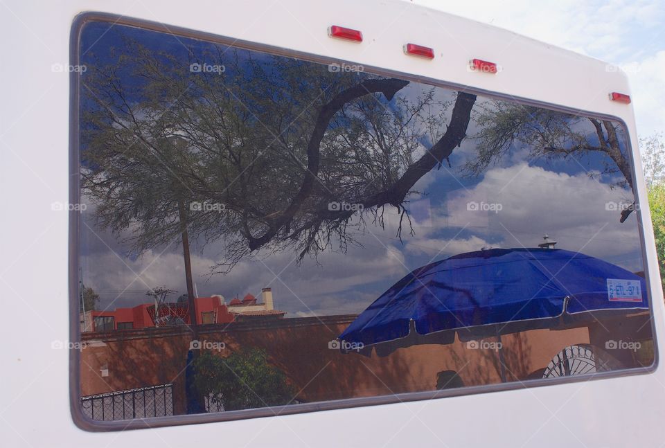 A reflection of San Miguel de Allende, Mexico as seen through the rear window of a parked van.