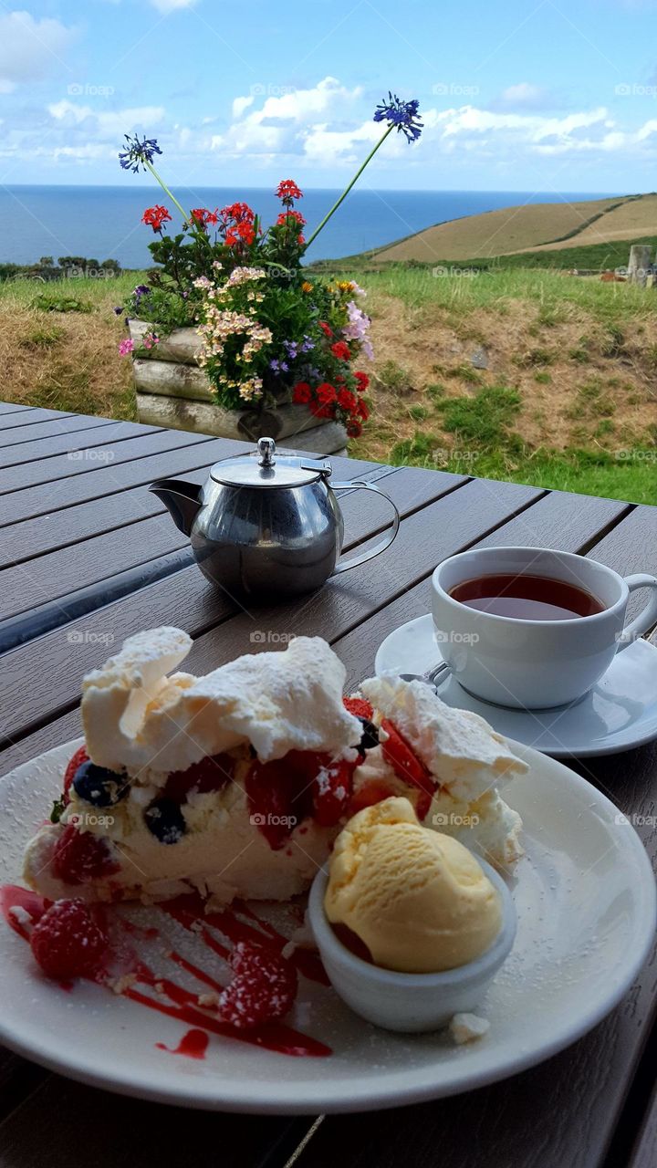 Summer treats! Tea time with delicious Pavlova cake with berries and ice-cream, and amazing view.