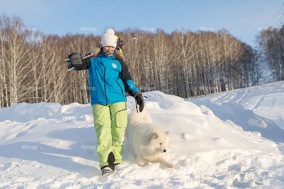 Woman walking with dog on snow