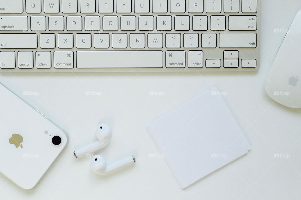 Computer and Apple cell phone on the white desk