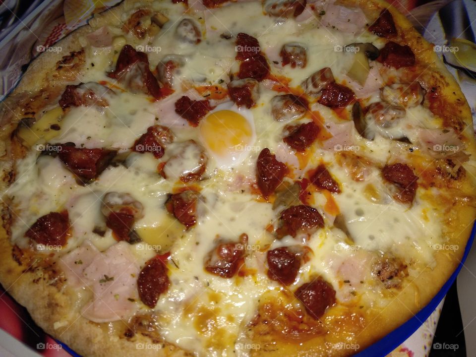 pizza casera recién hecha con huevo pavo champiñones chorizo y jamón de pavo y mozzarela