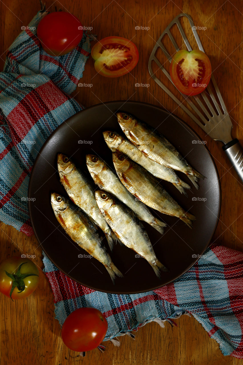 freshly cooked dried fish on a ceramic plate