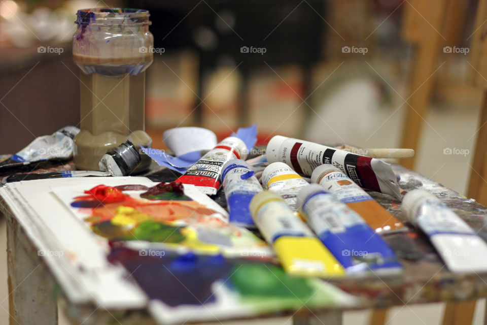 Paints and a mixing palette waiting to be used by an artist in a studio