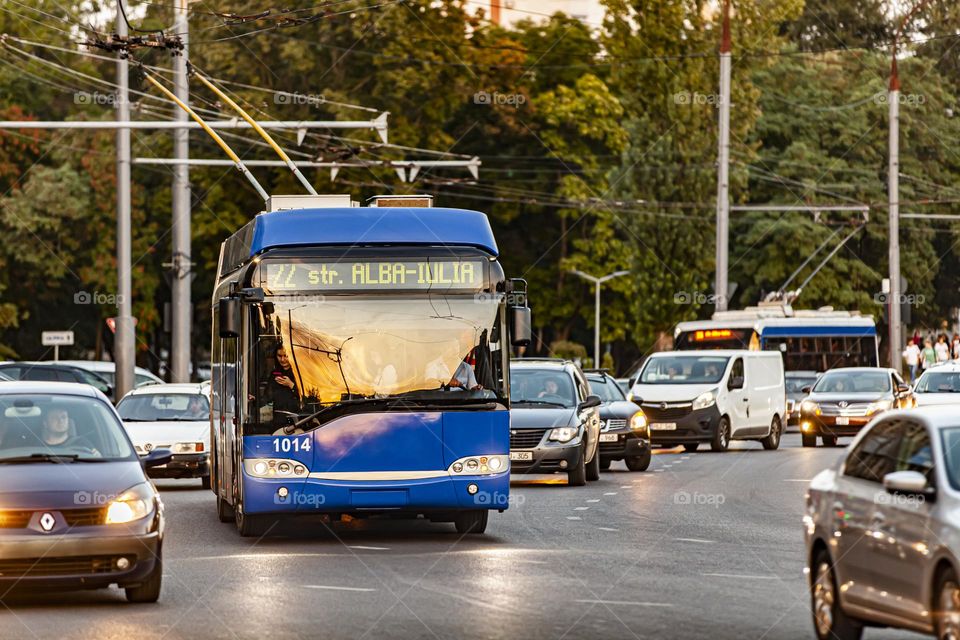 Blue trolleybus in traffic. Frontal view. Efficiency and environmental friendliness of transport.