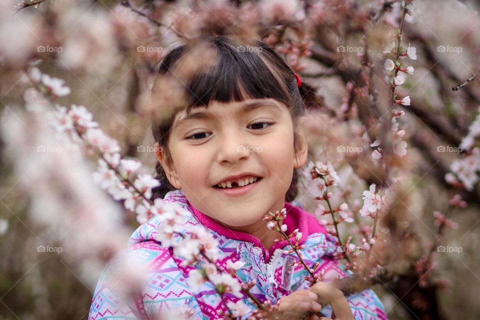 Cute little girl framed by blooming cherry tree