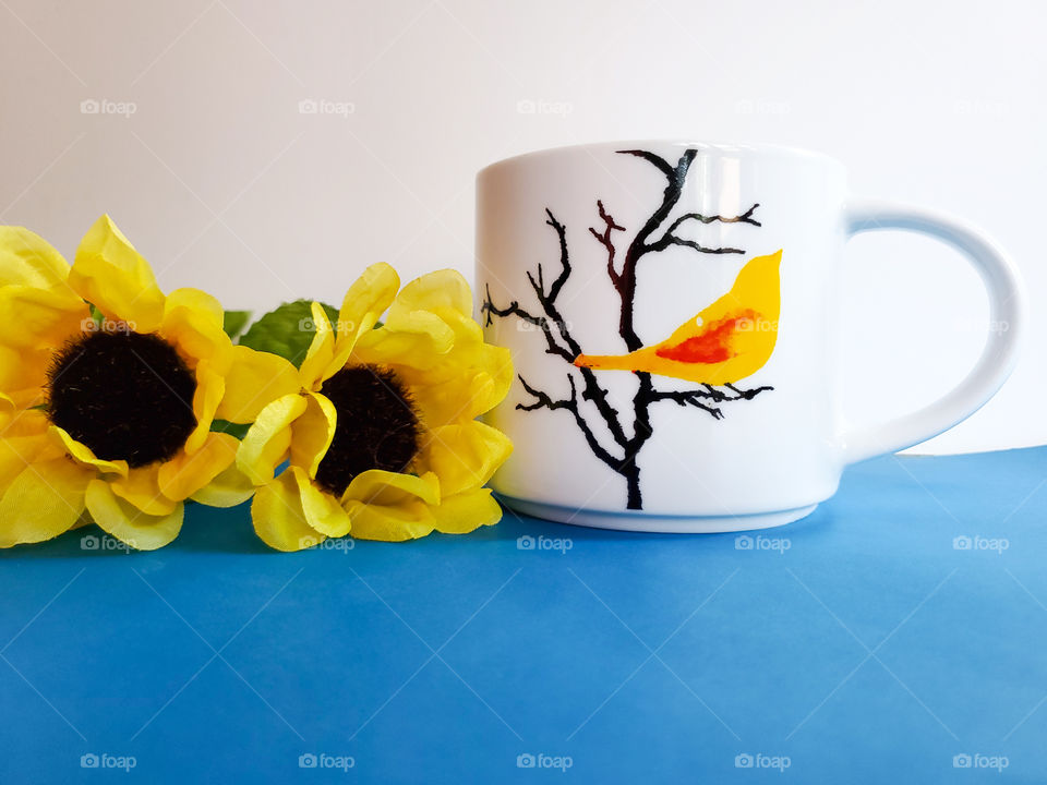 Favorite white coffee mug with a yellow bird on black tree branches.
