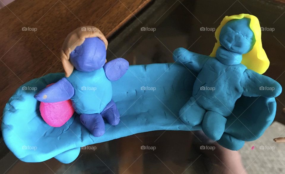 Creative girl, 7 yr old mind, with playdoo, built this beautiful blue curved sofa with pink pillows and 2 people lounging on it