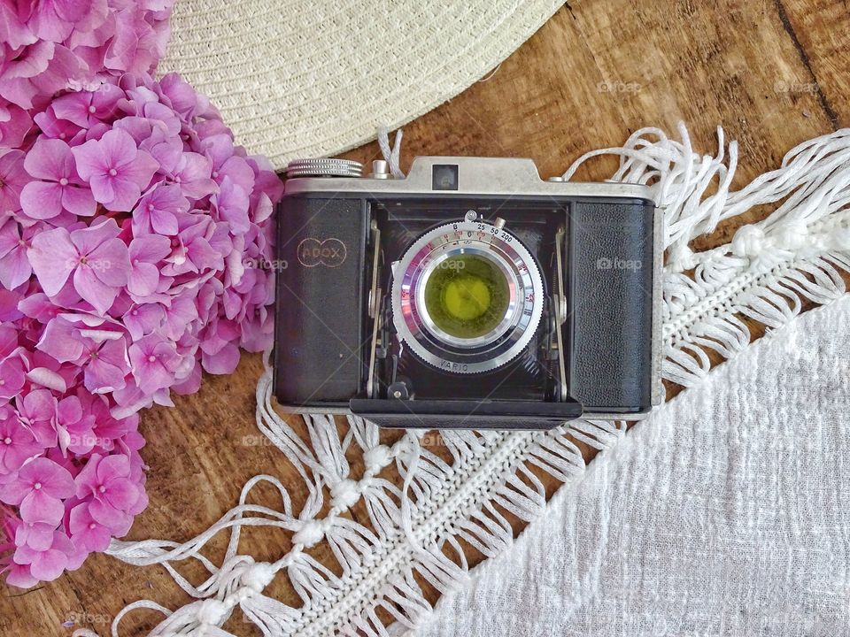 Still life with old camera and summer hat