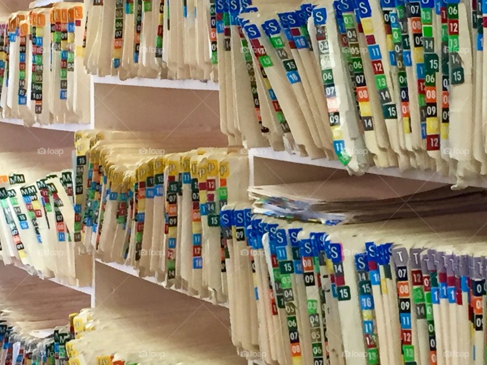 Shelves full of alphabetized patient files with colorful tabs at a doctor’s office