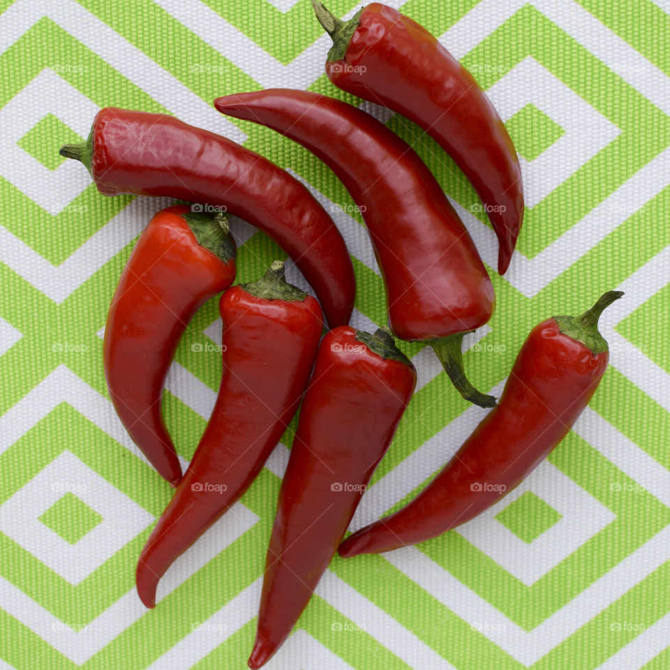 Red Peppers on a Green Background 