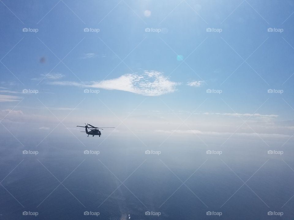 S70 type helicopter flying overwater.