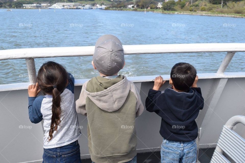 Three little boys looking out on the ferry