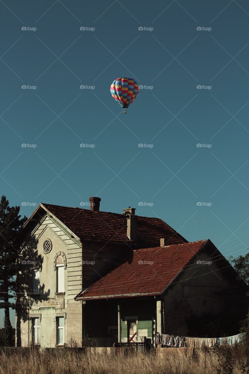 Old house and hot air balloon on sky