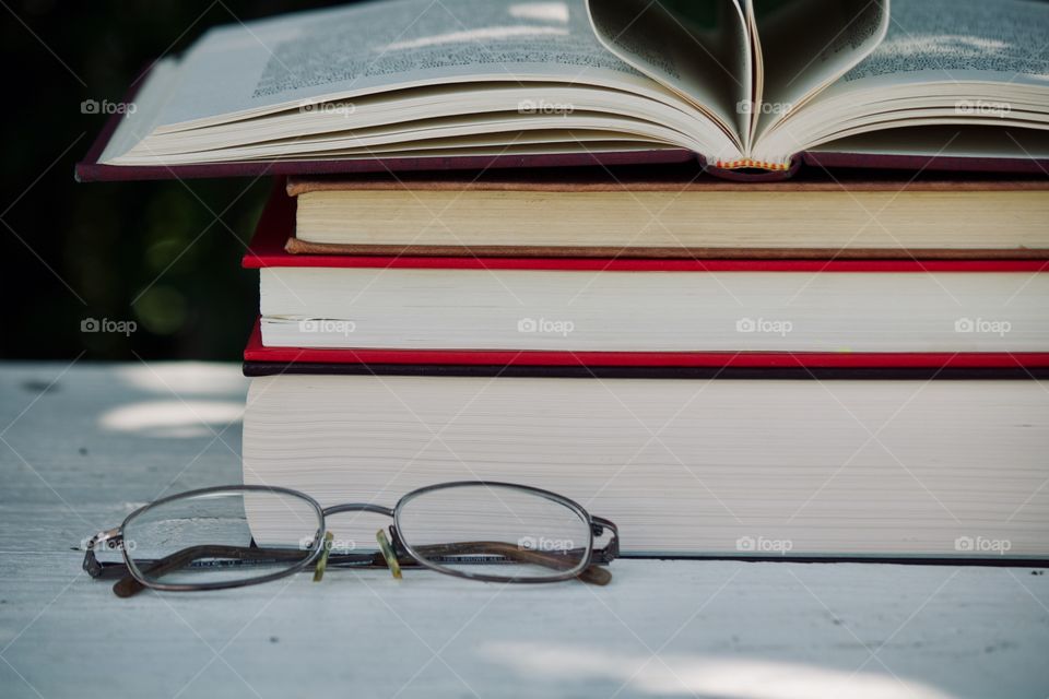 Reading glasses by a stack of books