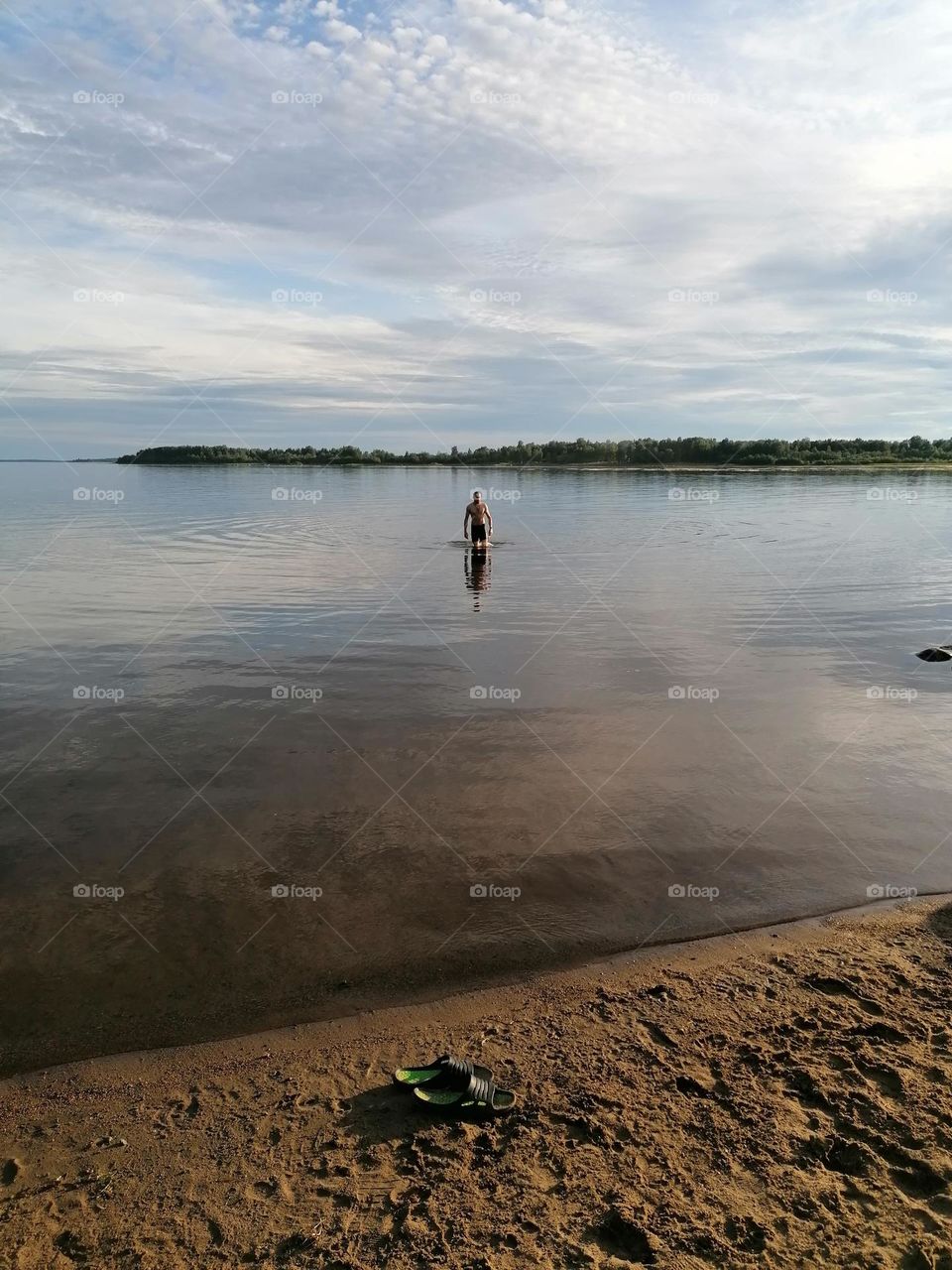A man swimming alone in the sea in Finnish Lapland in the summer