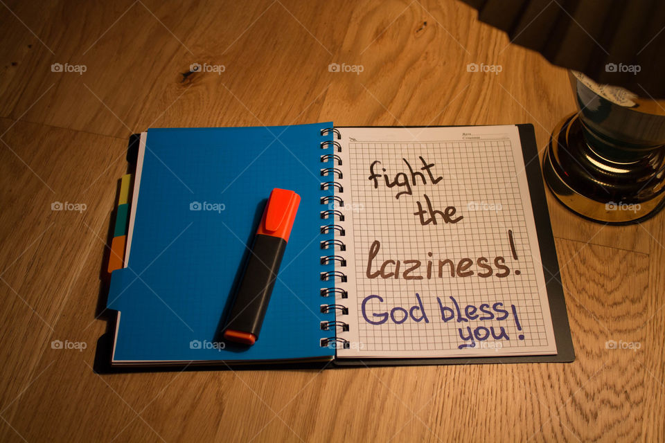 Motivational letter in a notebook on the desktop under the light of a lamp