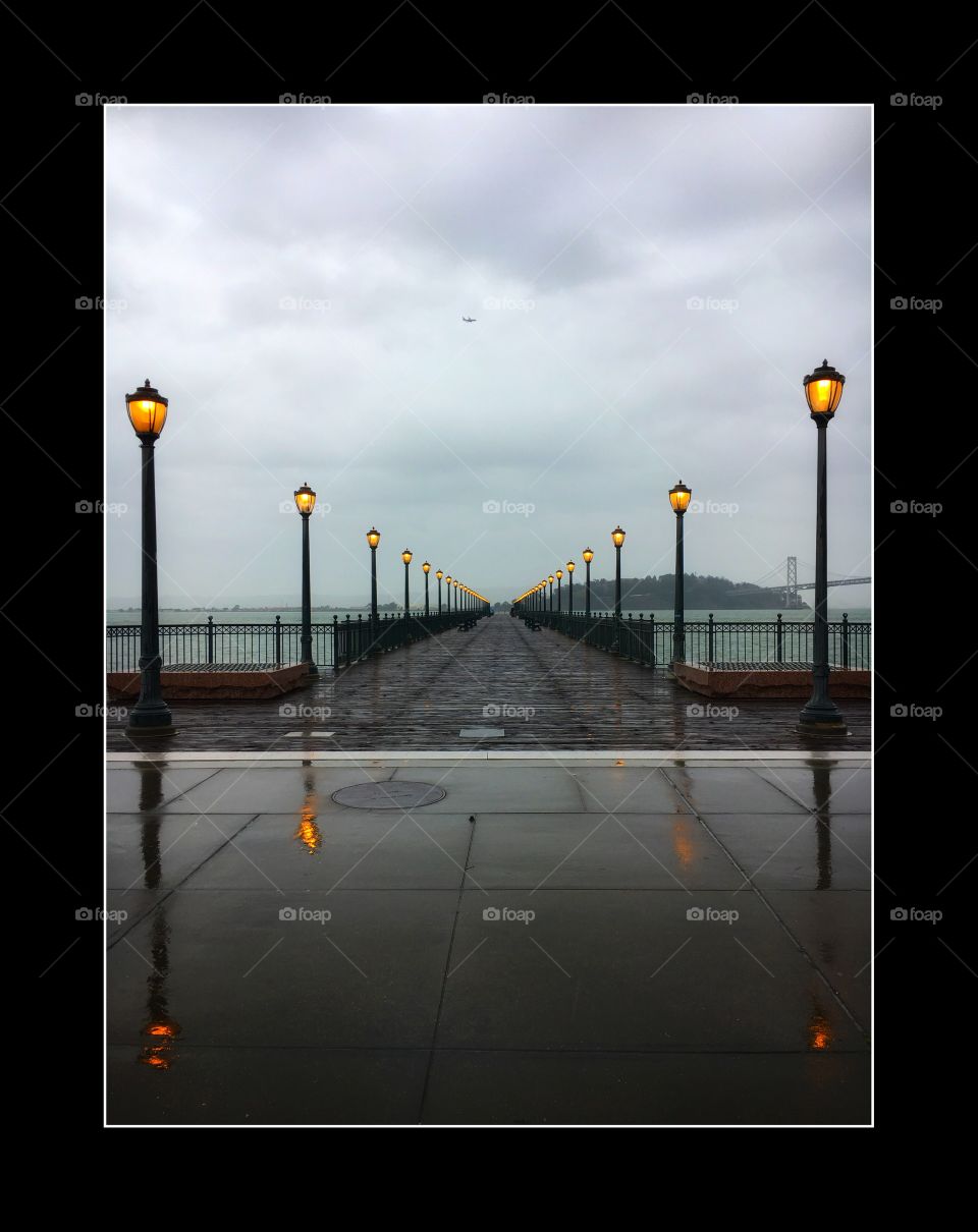 Rainy day pier in mirror paving