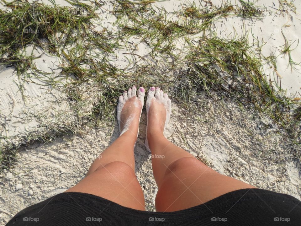 Barefoot on seaweed beach.