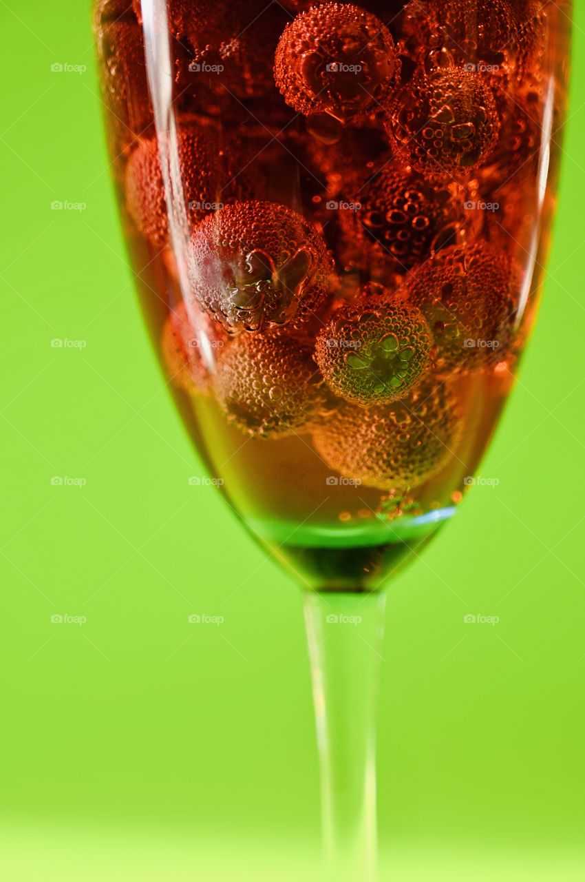 Bubbles on the Grapes in the wine glass with soda with green background. 