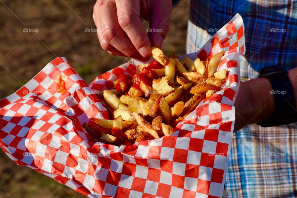 Close-up of man holding french fries