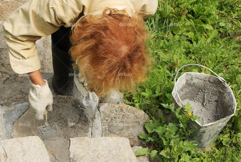 A woman makes plaster with concrete