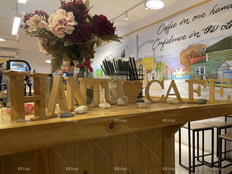 It’s a charming little cafe with cafe name on the counter top. Wall painted with cool drawings for mind relaxing.