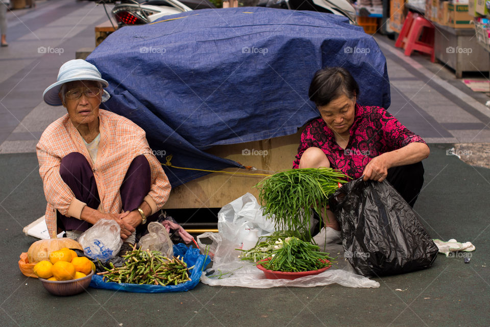 Women selling vegetables in Dongmun market, Jeju, South Korea.