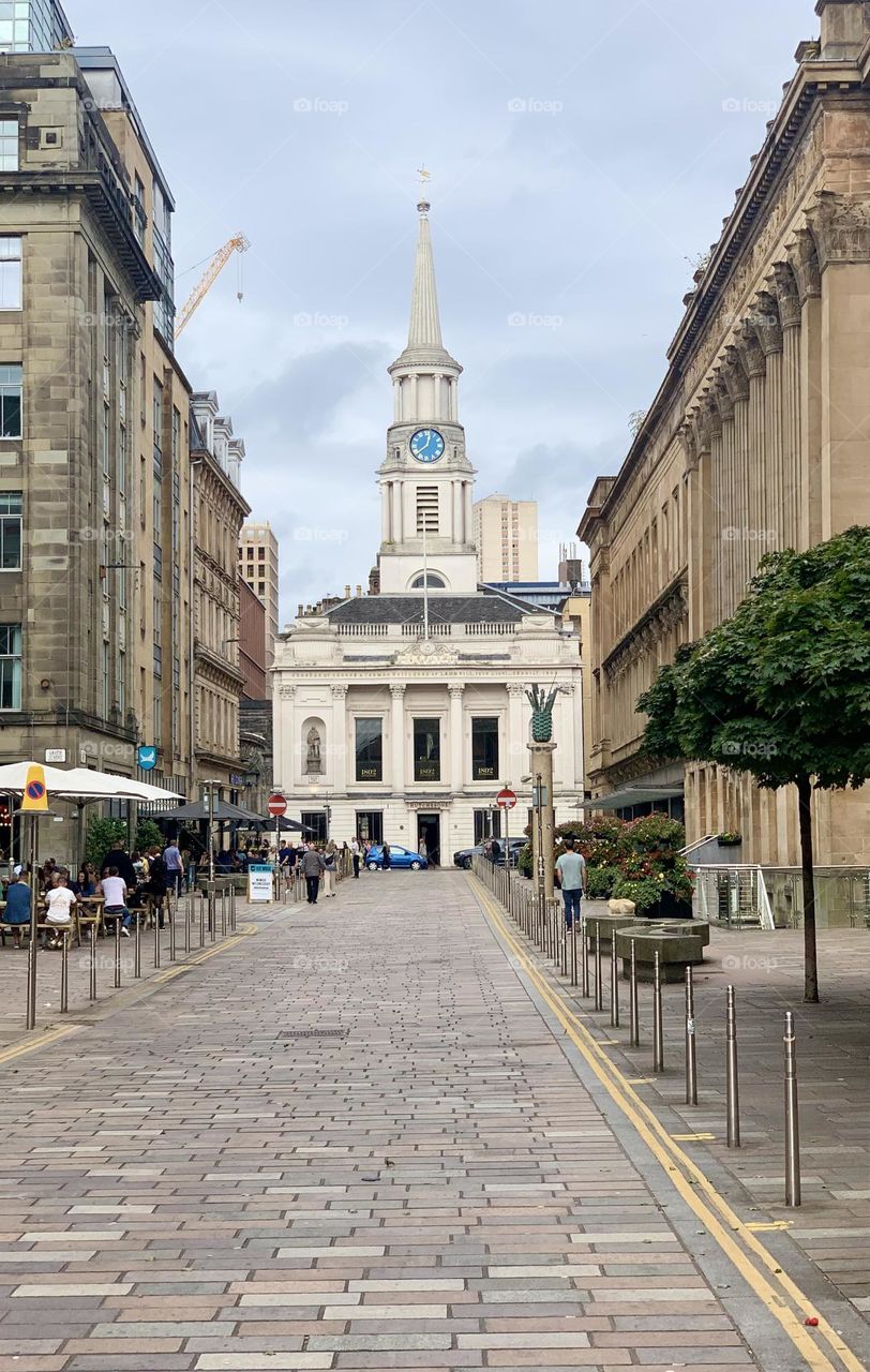 White church with tower and clock in city center