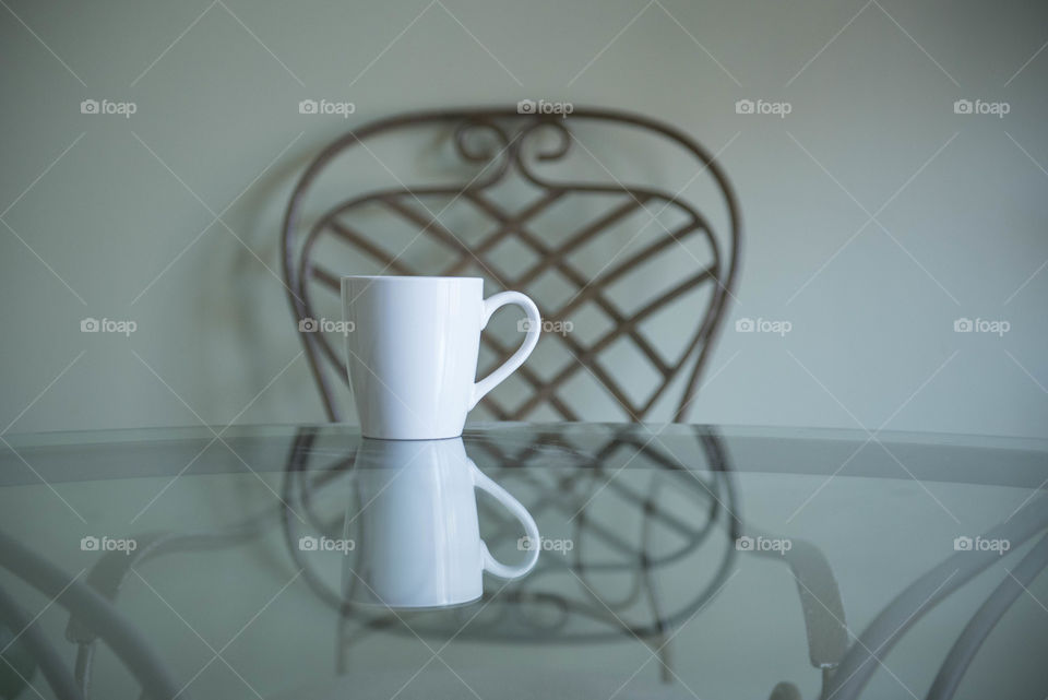 Isolated cup of coffee on a glass table indoors