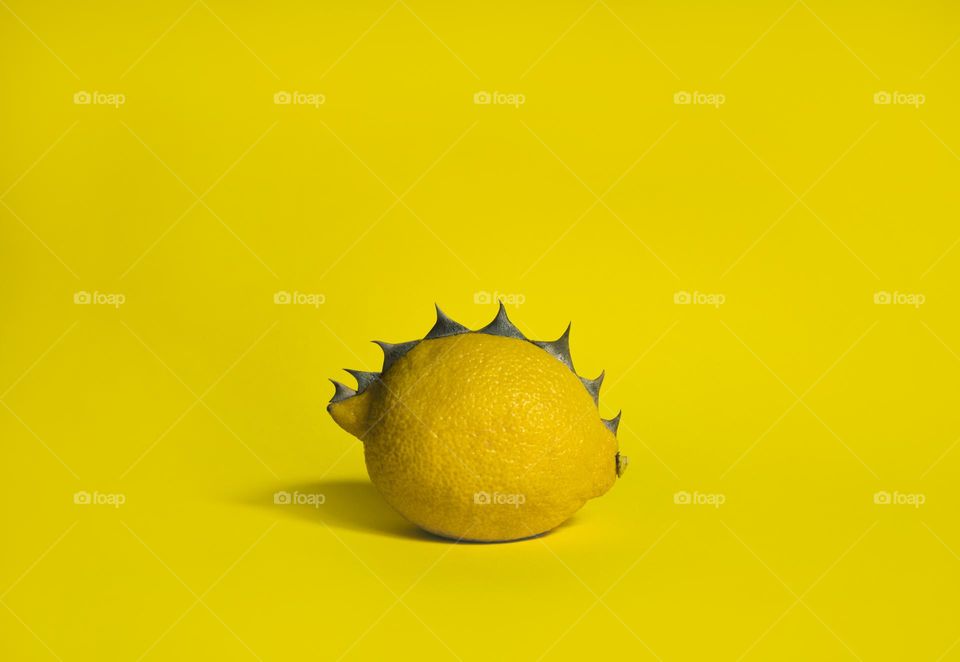 Yellow spiky lemon on yellow background