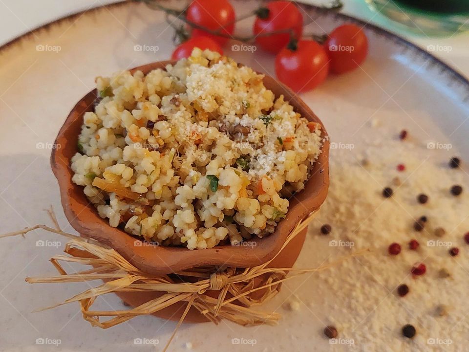 Delicious couscous with vegetables in an earthen bowl.  Vegan and vegetarian food.