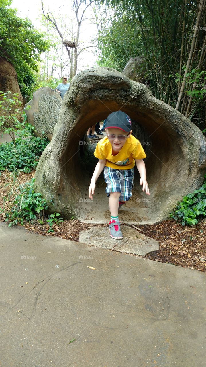 boy runs out of tunnel laughing