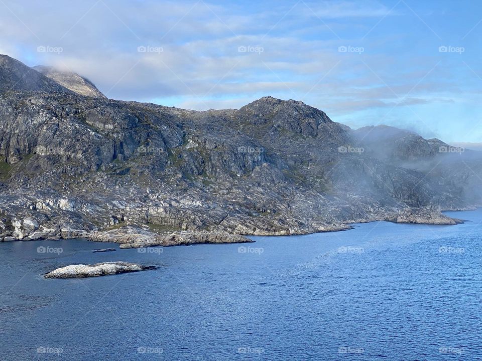 A mountain with a few wispy clouds 