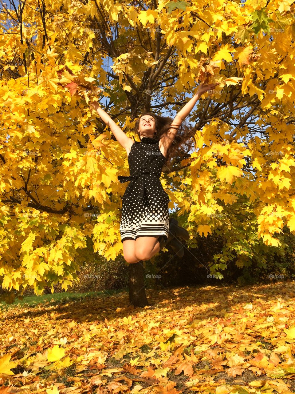 Yellow happiness . Jumping in the autumn yellow leaves