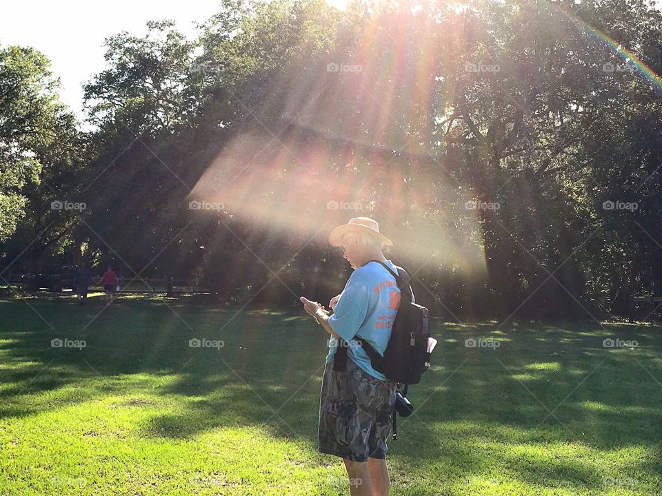 Hiker enveloped in rainbow sunshine.