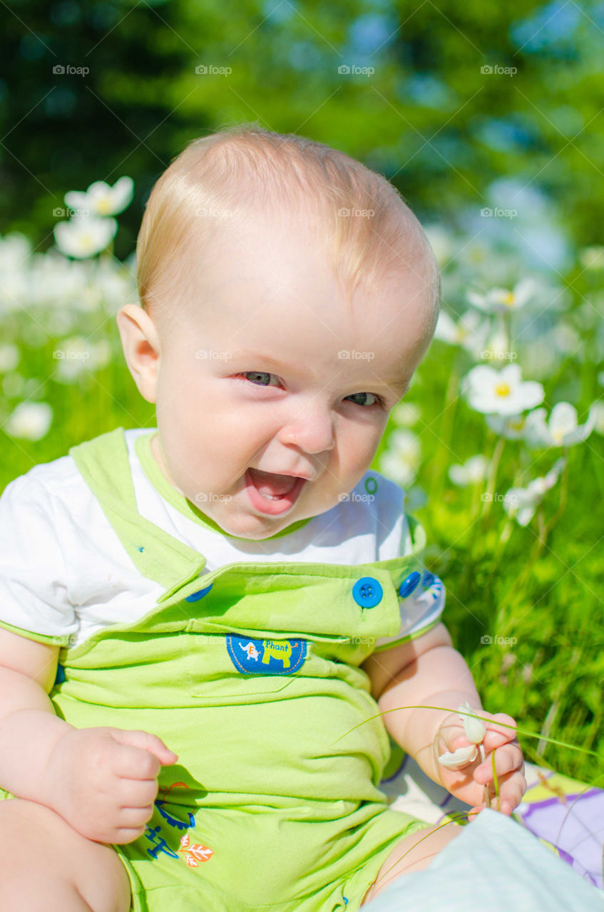 Portrait of a toddler sitting on flower field