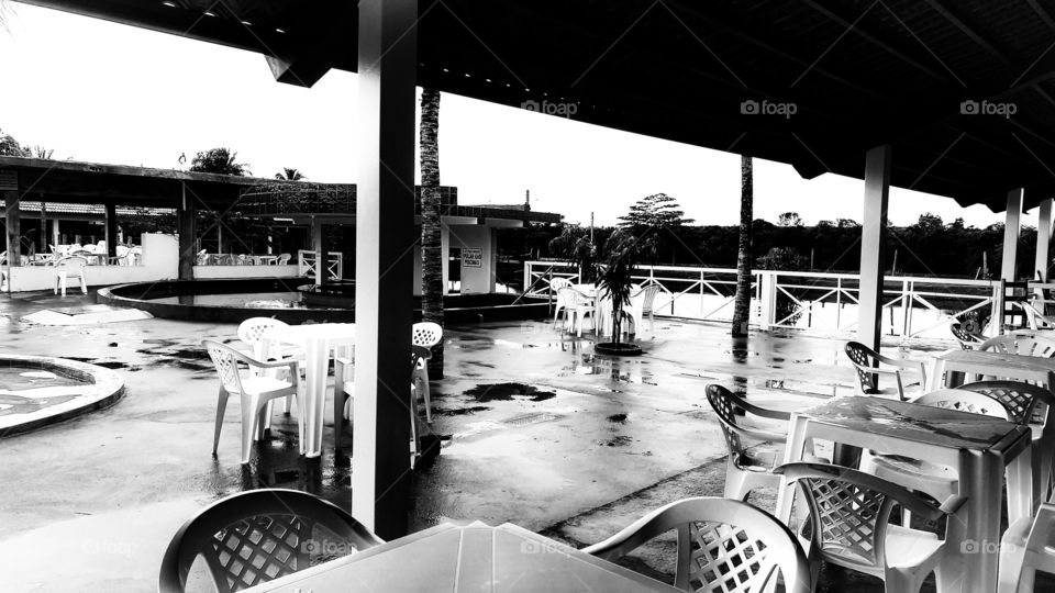 Cadeiras e mesas de plastico em patio de piscinas.