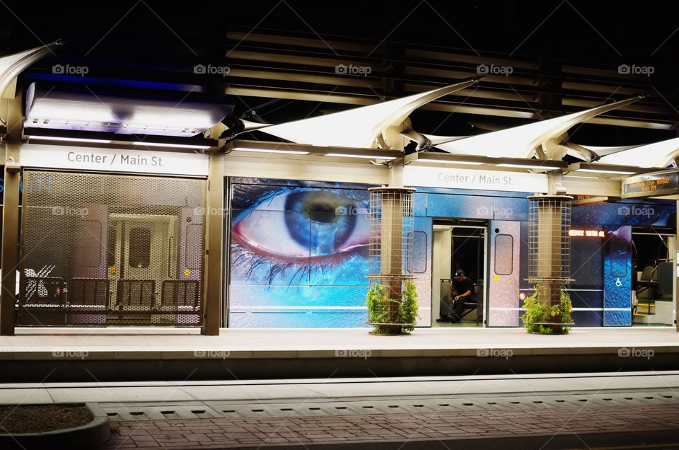 This is a light rail station in Downtown Mesa, AZ. The side of the light rail cars were decorated with a photo of two giant eyes, and when it stopped at it's station, this made for some wicked cool photos. 