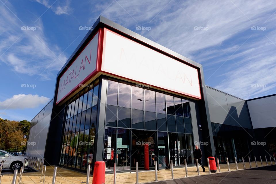Modern glass fronted store against not a beautiful blue sky